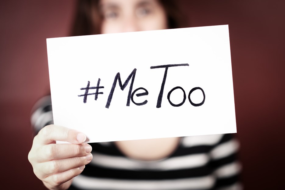 En kvinna som håller upp en skylt med texten "MeToo".