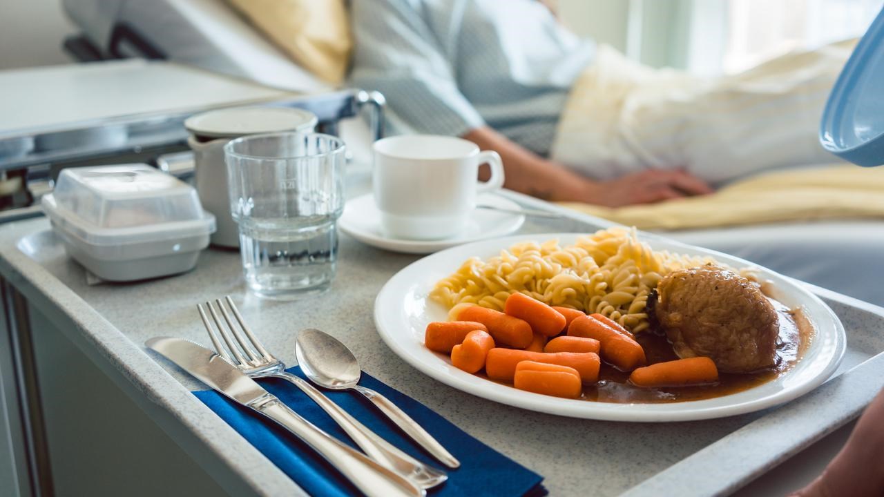 Sängliggande patient har fått en bricka med mat serverad på ett sjukhus.
