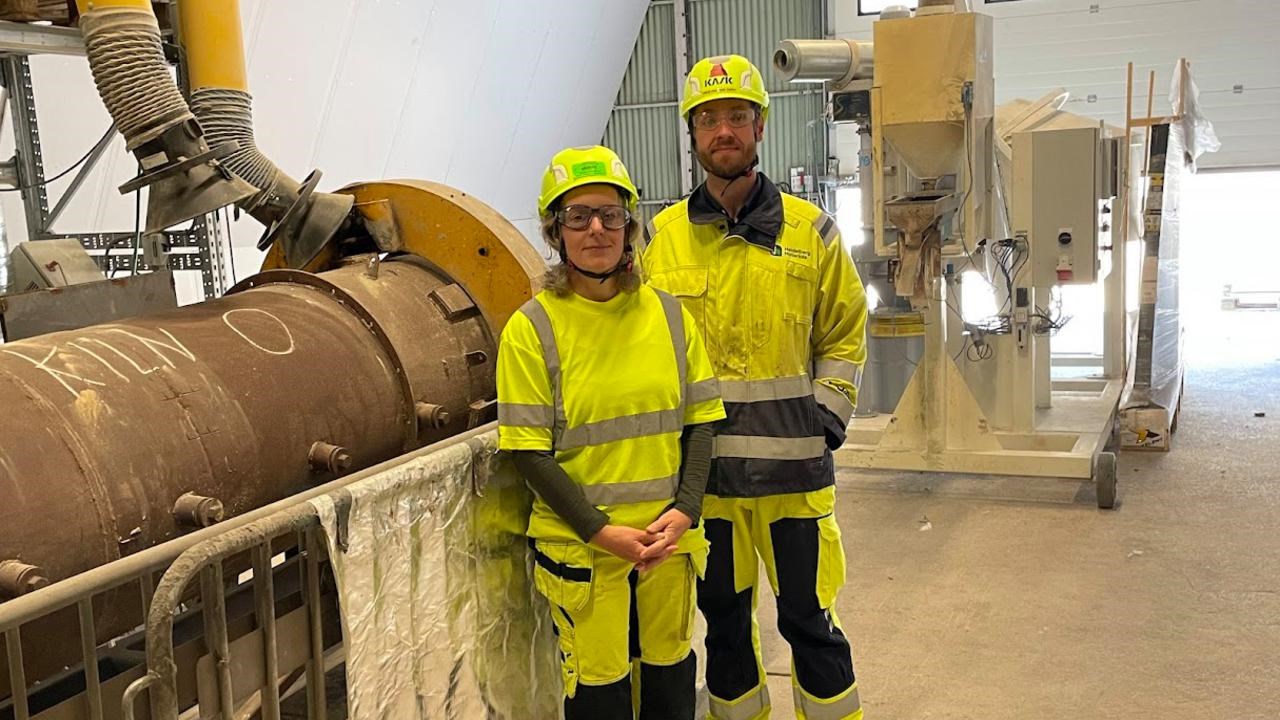 Tv&aring; personer i varselkl&auml;der vid en cementugn.