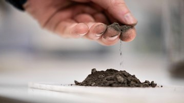 En hand som håller i aska.