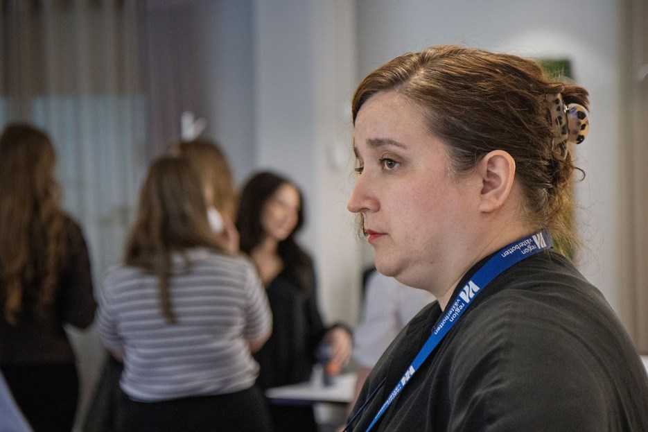 En kvinna som står framför en grupp människor.