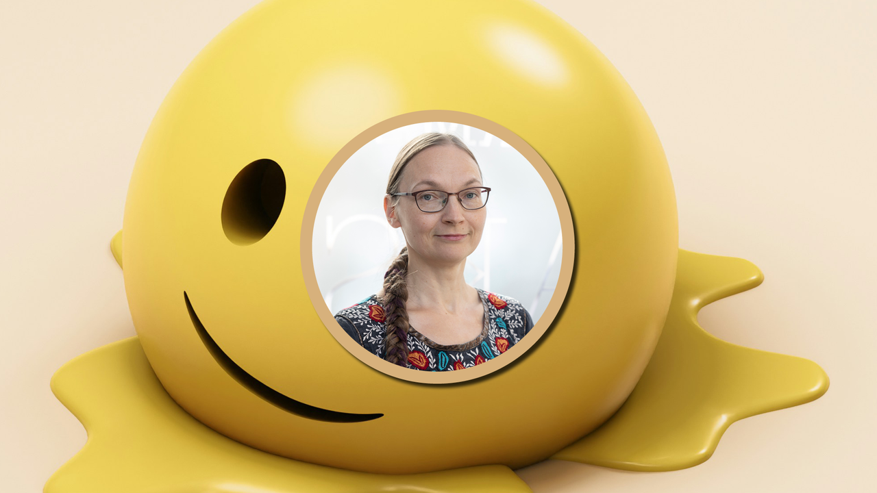 En kvinna med glasögon och ett leende på läpparna.