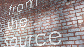 A brick wall with the text 'from the source' written on it.
