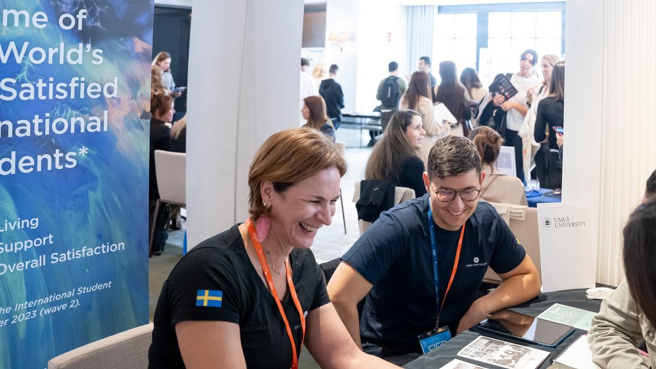 Representatives from Umeå University in a student fair, talking to prospective students.