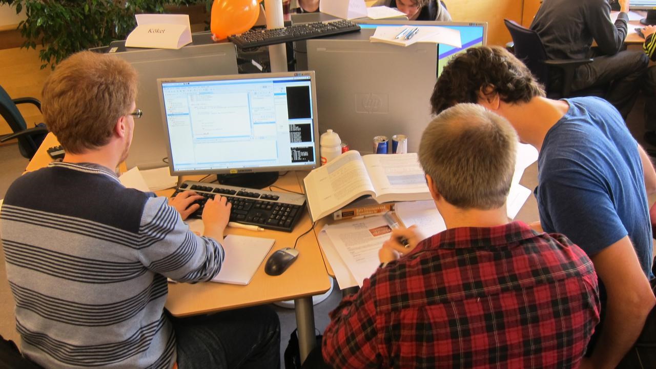 En grupp människor som arbetar med datorer på ett kontor.