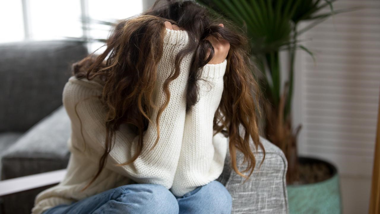 Kvinna som d&ouml;ljer sitt ansikte i sina h&auml;nder. Ska illustrera psykisk oh&auml;lsa, depression, nedst&auml;mdhet eller liknande.