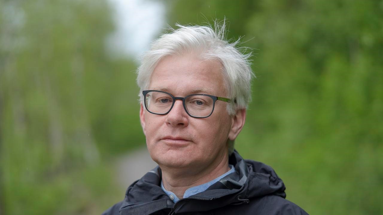 En man med glas&ouml;gon som st&aring;r p&aring; en grusv&auml;g.