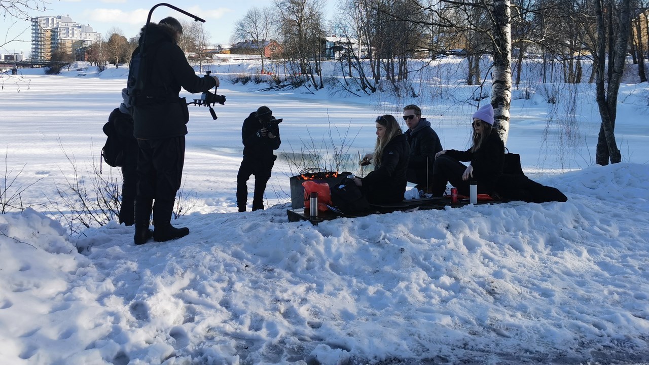 Personer sitter och grillar och blir samtidigt filmade.