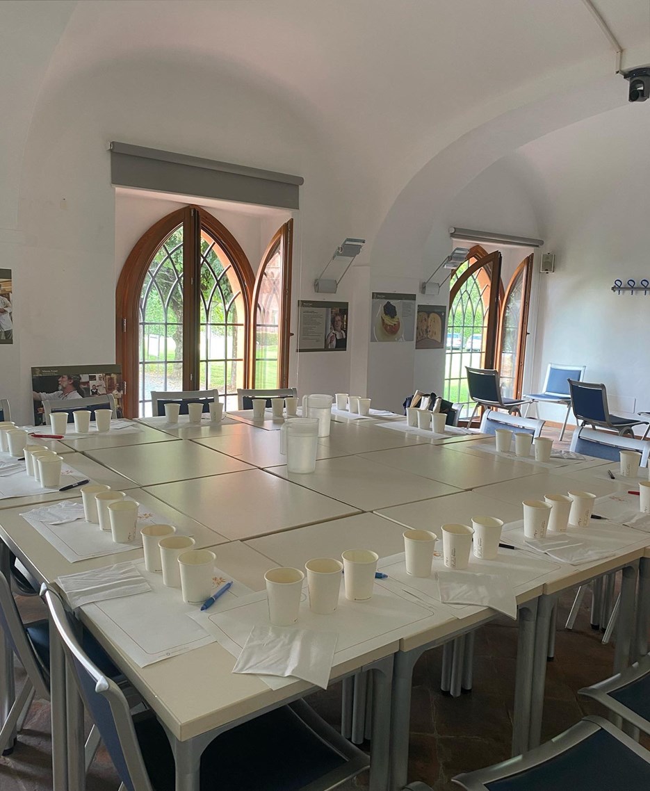 A table with mugs and note sheets for a tasting.