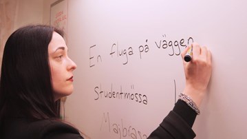 Kvinna skriver på en whiteboard.