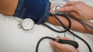 Vårdpersonal mäter blodtrycket på en patient.