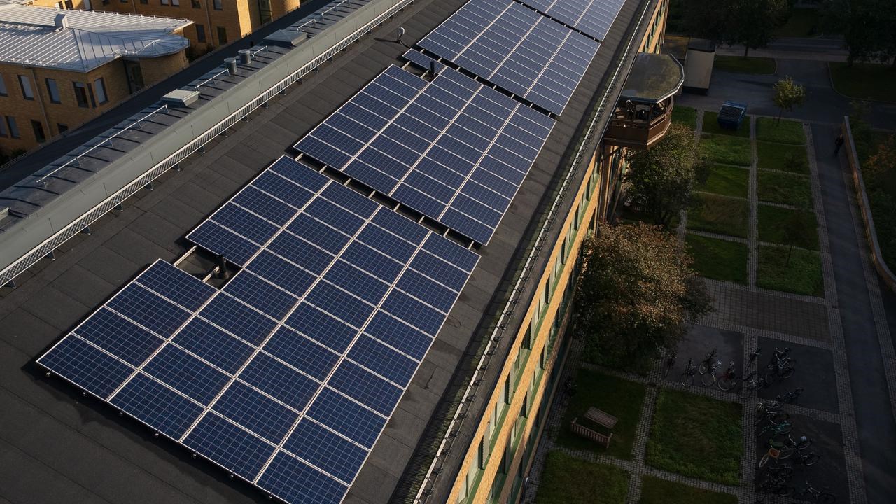 Solceller &auml;r installerade p&aring; ett tak p&aring; en byggnad