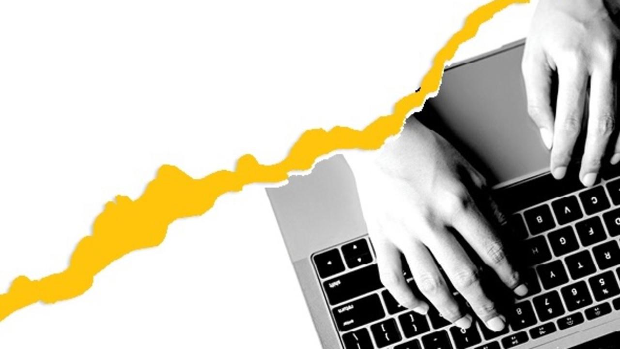 torn paper on top of hands on computer