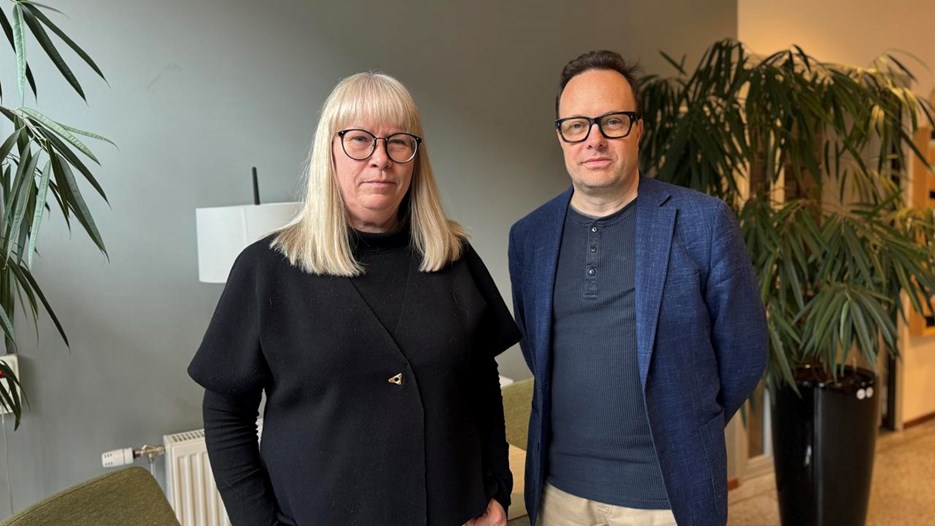 Man och kvinna poserar framför en vägg