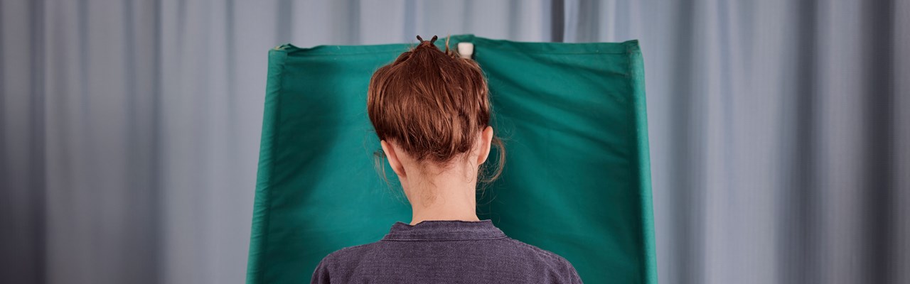 Kvinna står i valbås.