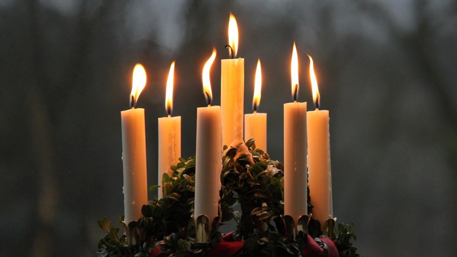 Närbild på luciakrona med tända ljus.