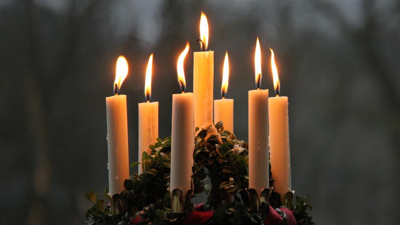 Närbild på luciakrona med tända ljus.