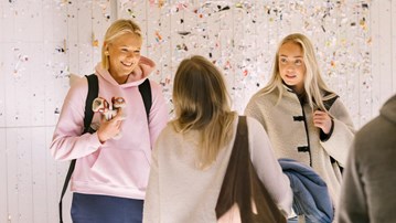 En grupp studenter står och samtalar i Lärarutbildningshuset.