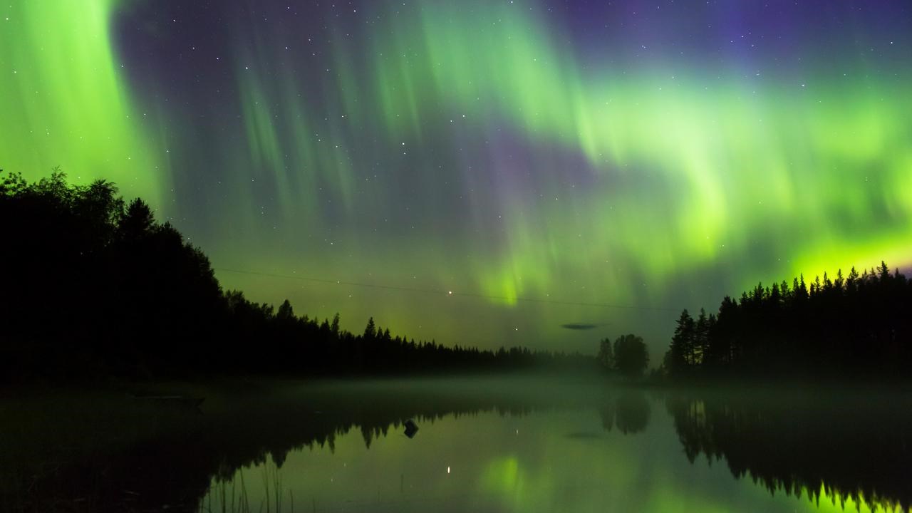 Norrsken som speglas i &auml;lven.