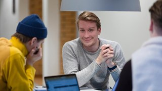 Tre studenter sitter och pluggar vid ett bord i naturvetarhuset