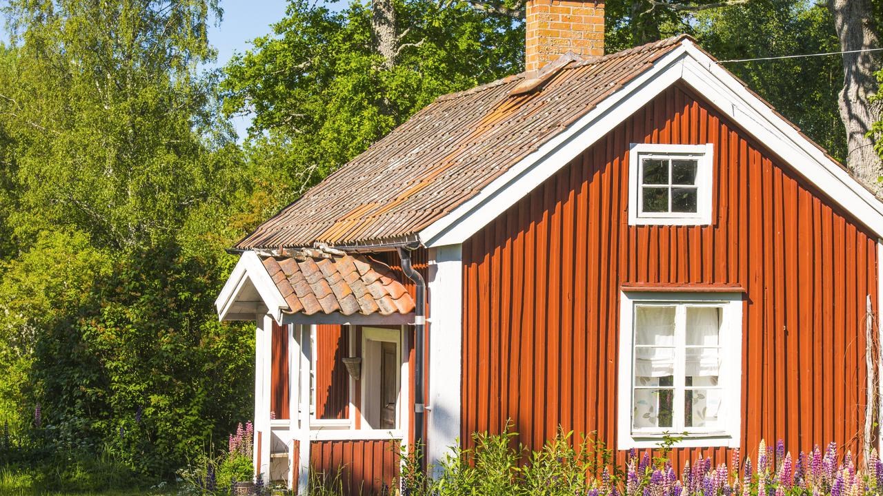 En r&ouml;d liten stuga p&aring; svenska landsbygden.