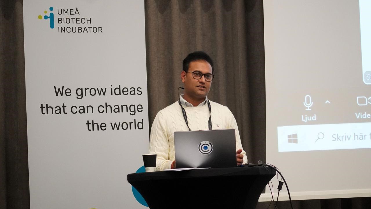 En man st&aring;r p&aring; ett podium med en b&auml;rbar dator framf&ouml;r sig.