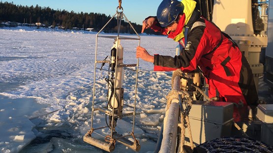 enperson hanterar provtagningsutrustning på ett fartyg