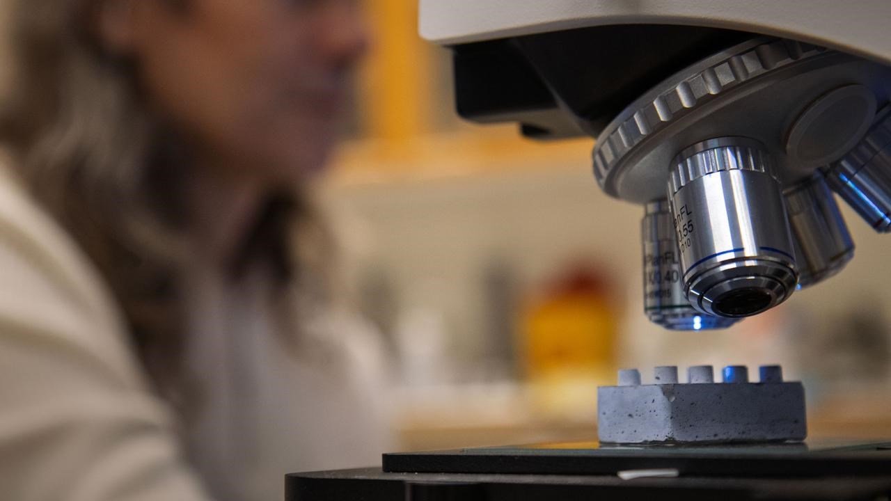 En legobit i cement under ett mikroskop