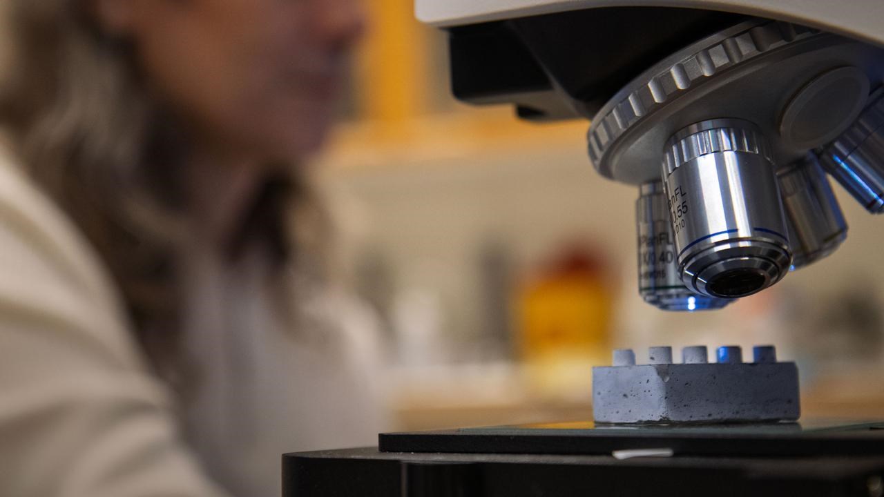 En legobit i cement under ett mikroskop