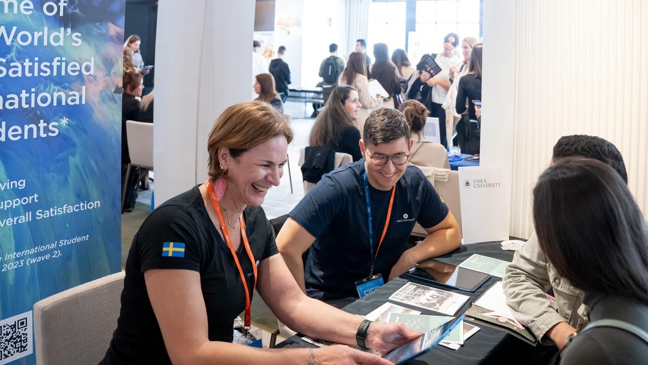 Representatives from Umeå University in a student fair, talking to prospective students.