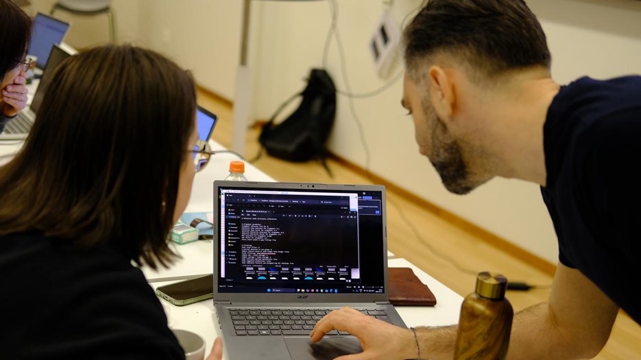 Two persons looking at a computer program