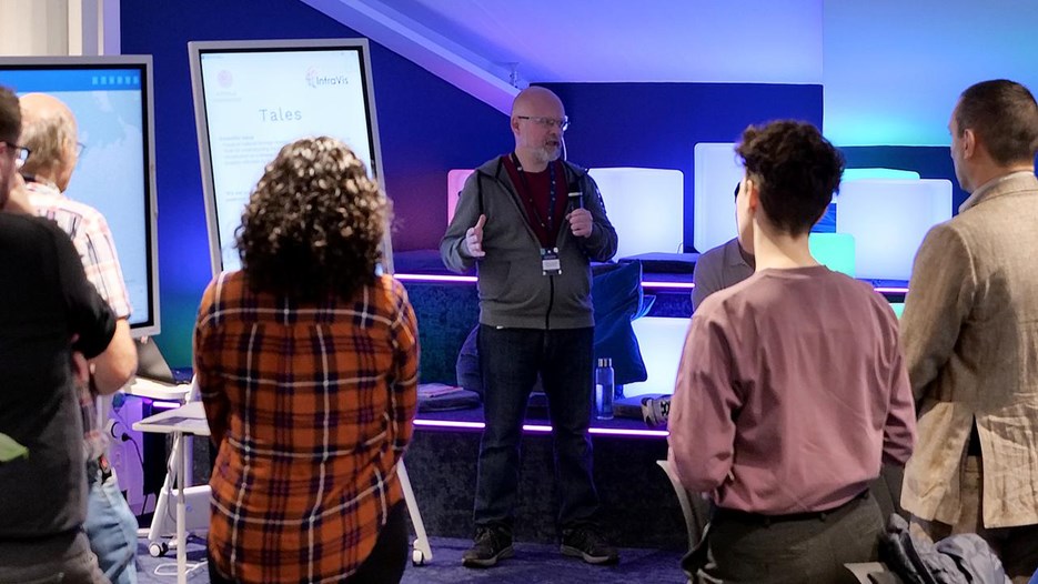 En grupp människor som står framför presentationsskärmar.
