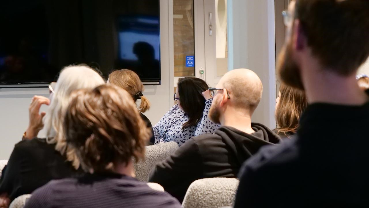 En grupp människor som sitter i ett rum och tittar på en presentation.