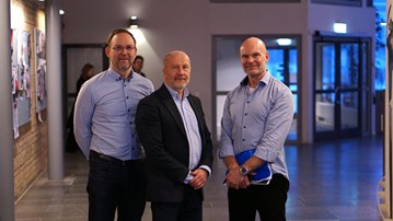 En grupp om tre män som står bredvid varandra.