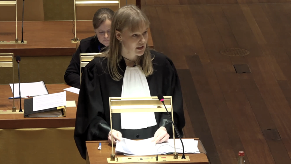 En kvinna står vid ett podium i ett rum.