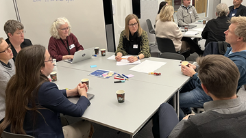 En grupp människor som sitter runt ett bord.