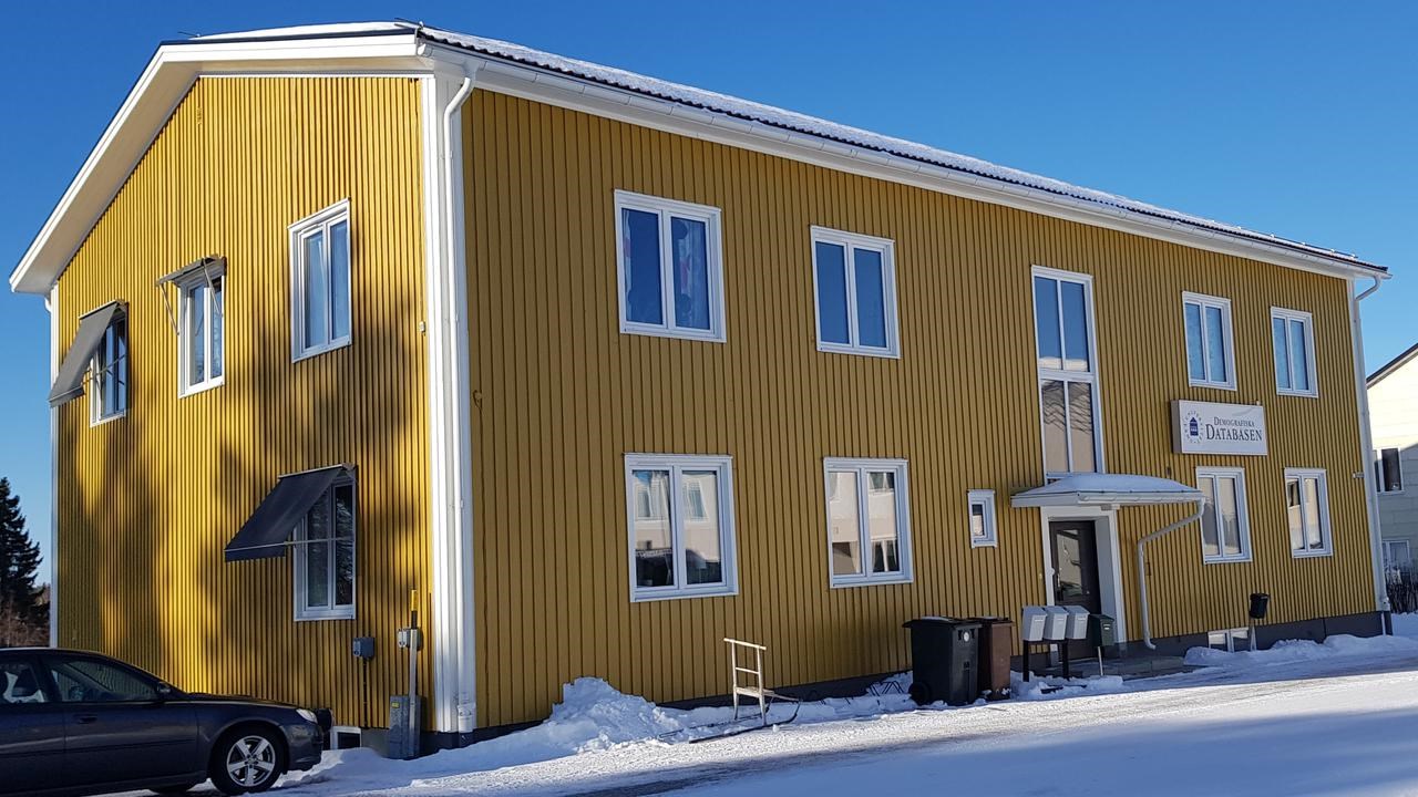 En bil parkerad framf&ouml;r en gul byggnad.