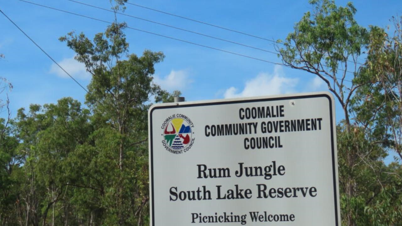 En vit skylt som sitter mitt i en skog