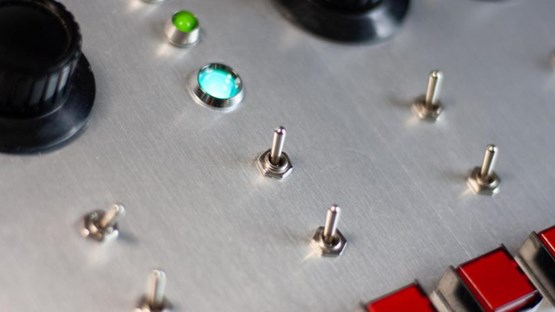 A close up of a control panel with buttons and knobs.