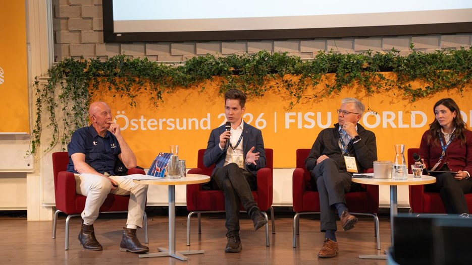 4 personer på en scen i ett panelsamtal. Joakim håller i en mikrofon och pratar.