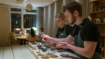 Studenter förbereder måltid i köksmiljö.