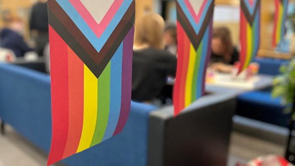 LGBTQI-flag and students in a sofa