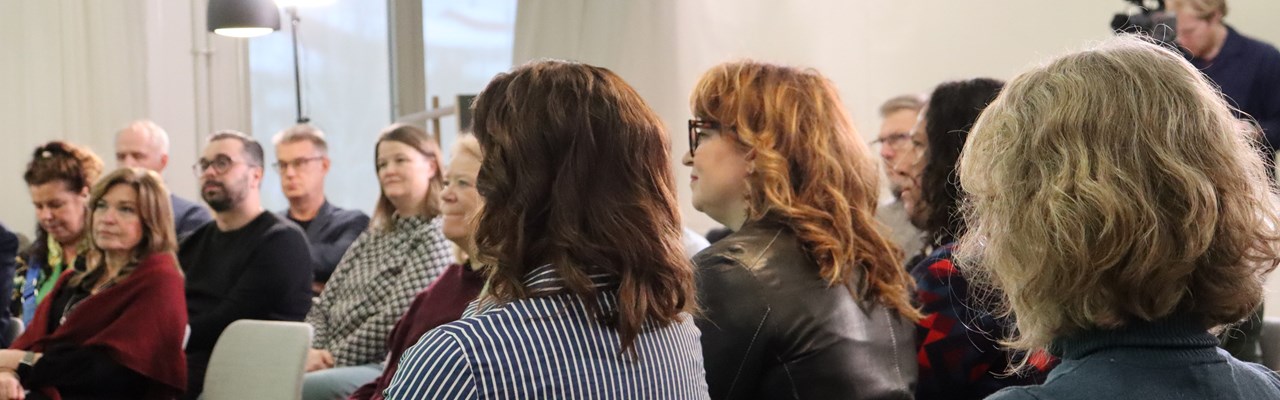 En grupp människor som sitter i stolar i ett rum.