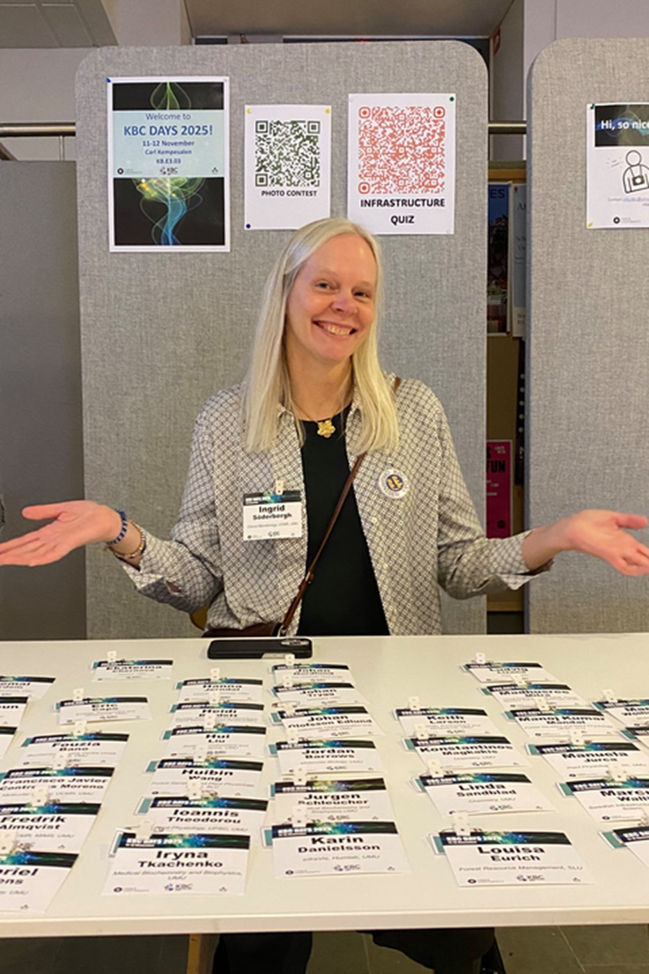 A woman behind the registration desk, where conference name badges are located 