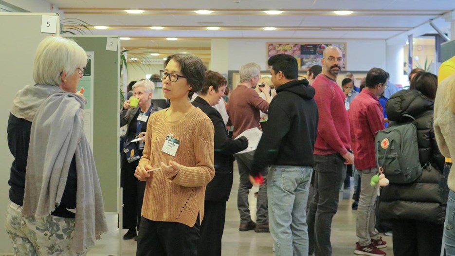 A group of people mingling and talking during the conference coffee break