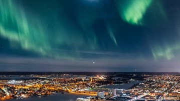Norrsken i grönt över en stad.