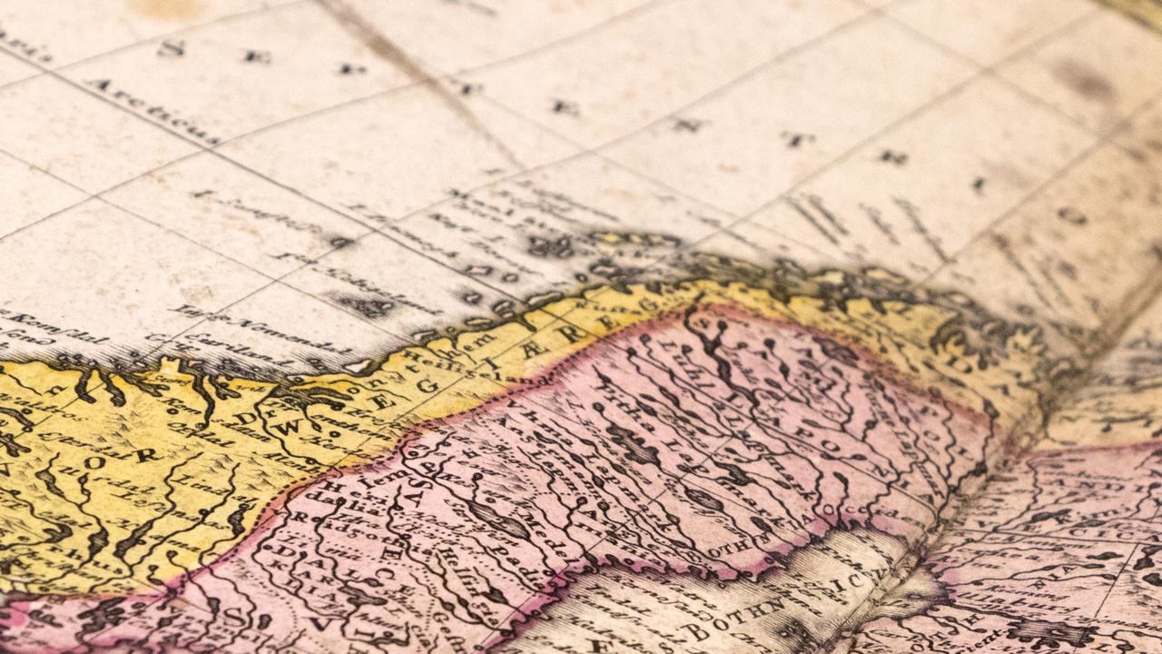 Uppslag av en gammal kartbok över Sverige