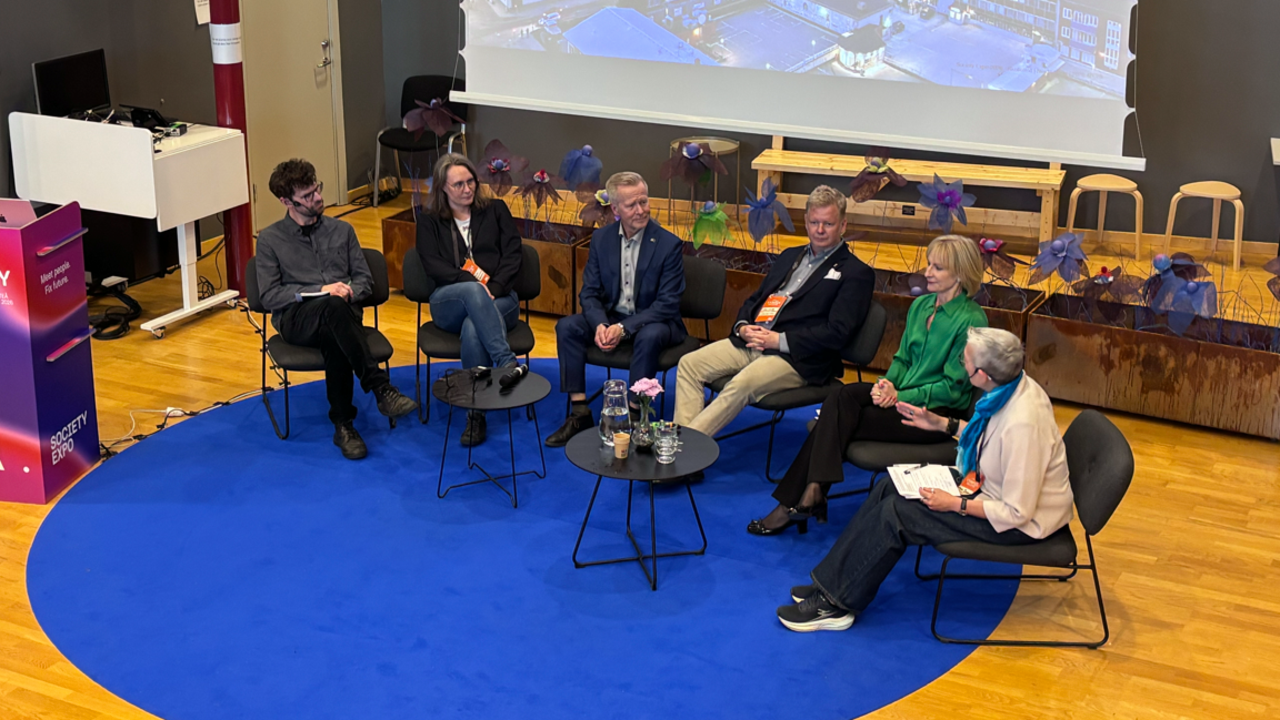 En grupp m&auml;nniskor som sitter p&aring; stolar framf&ouml;r en projektorsk&auml;rm.