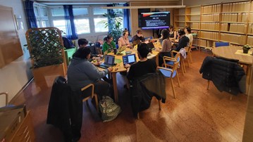 People sitting around a table concentration on writing.