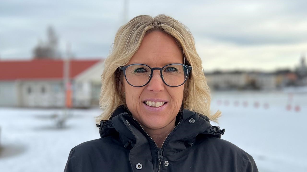 En kvinna med glasögon står i snön.